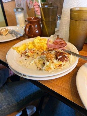 Two scrambled eggs, hash browns and ham.