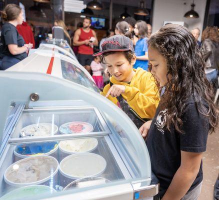 Customers picking their favorite ice cream flavor, Superman, available at Sweet Aloha Ice Cream in Davie, Florida.