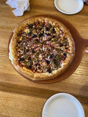 Most delicious pizza with hamburger ham black and green olives mushrooms and made with kindness.