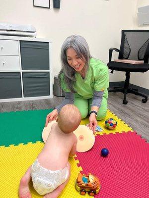 Kim enjoys playing with an active and interested baby while her mama pumps.