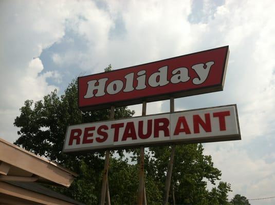 Restaurant sign off road at base of bridge.