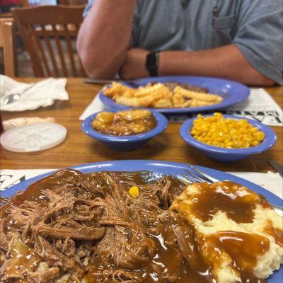 Open faced pot roast sandwich with mashed potatoes and corn, steak and French fries with baked apples.