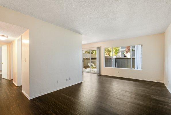 Living room with hardwood style vinyl flooring and sliding glass patio doors.