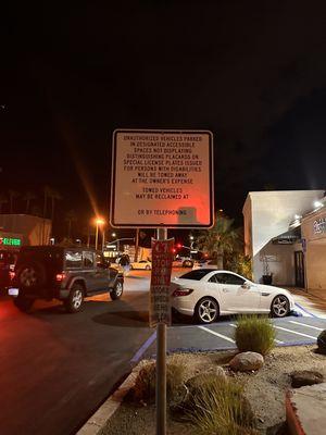 Bent sign stating that parking is only for Rick's Desert Grill