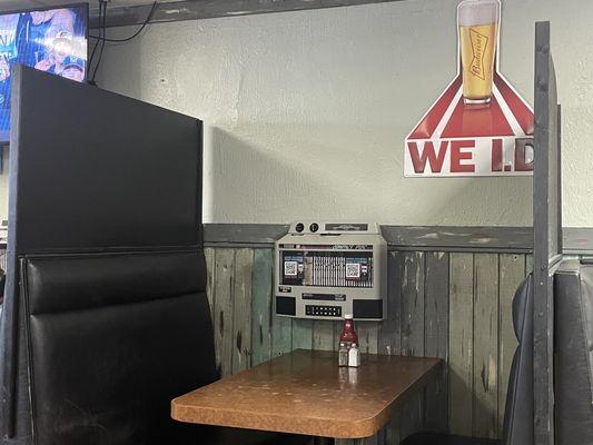 Old fashion jukebox in the middle of the table. High extended walls just in case of a food fight?