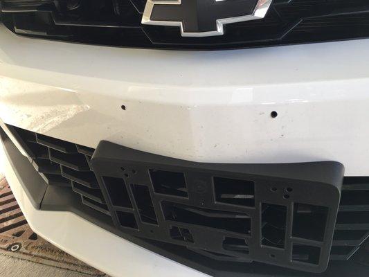 Where this dealership service dept drilled holes in my front bumper