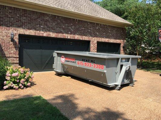 10 yard dumpster with boards under the rollers to protect your driveway.  We call this the "PPP".  Pavement Protection Plan.