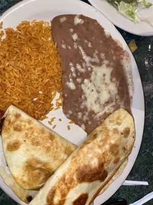 Two shrimp quesadilla dinner with a side of rice, beans, guacamole salad, and cheese dip.