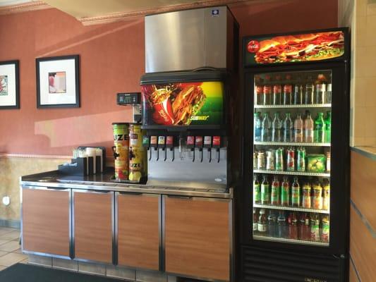 Soda and juice machine along with bottled beverages.