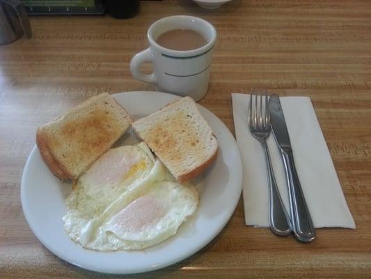 Two eggs over medium with toast and coffee.