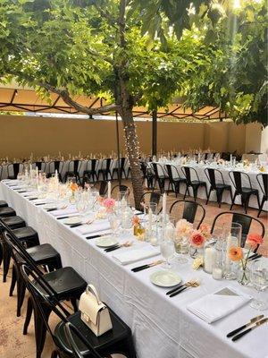 Long dinner tables in the courtyard under the trees!