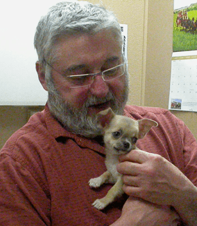 Our wonderful doctor, Frank Frucci, introducing himself to a new puppy for the first time.