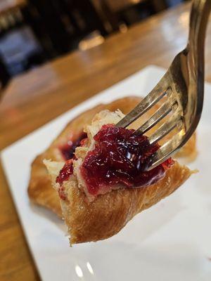 A fork holding a piece of my nice and fresh Cherry Danish.