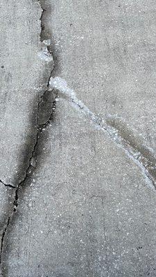 Gouges and new cracks on my driveway, caused by the placement of Sheegog's waste dumpster.