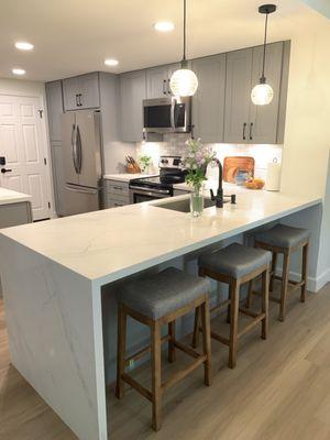 After picture with the wall removed to give the kitchen an open concept. Water fall quartz island.