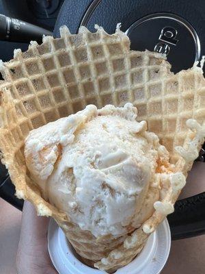 Peach ice cream in a waffle cone