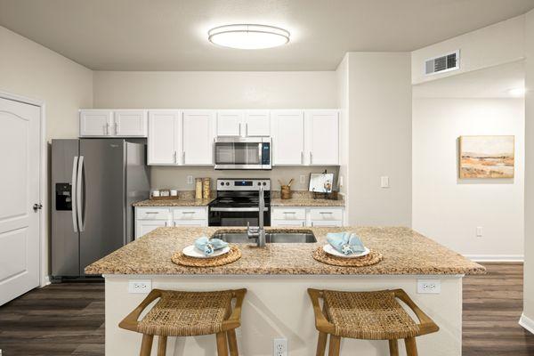 Kitchen with stainless steel appliances and kitchen island at Onion Creek Luxury Apartments