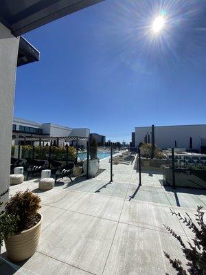 Pool area with day beds, sofas, lounge chairs. The fire pits and BBQ Grills with seating can also be seen.