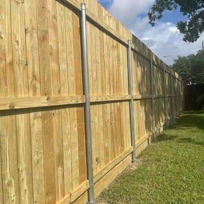 9' treated pine fence with heavy wall, galvanized, steel posts. 2x12" rot board, 8' treated pickets.