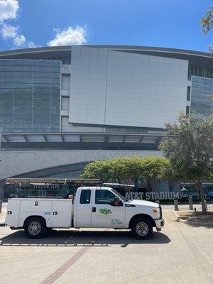 A Tioga Plumbing And Electric service truck in front of the AT&T stadium in Arlington Texas.