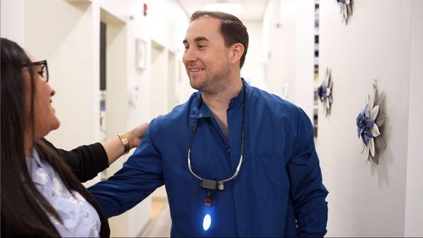 Dr. Joshua John being thanked by a patient for helping her achieve a renewed smile