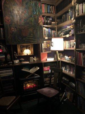 A little room behind a curtain invites you to sit in a chair and look at a few books - super dark and cozy.