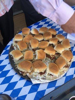 Pulled pork from a blag slopped onto a Hawaiian bun with crispy onions and a bag of coleslaw