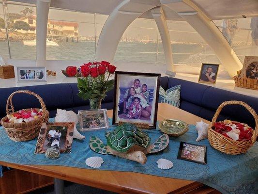 Decorated memorial table with pictures and turtle urn