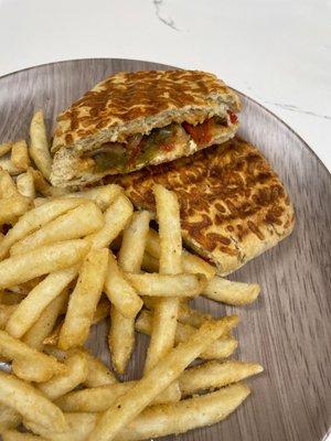 Sausage and peppers sandwich with fries.