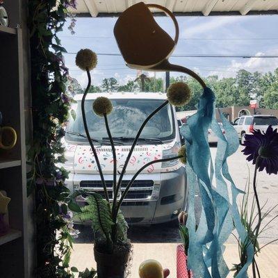 Cute watering can and flower arrangement in their display window. They also deliver!