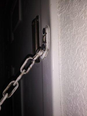 The chain on the door for security is half off