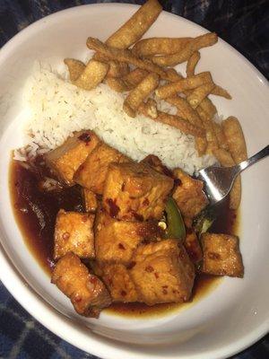 Half portion of General Tso's Tofu with some steamed rice and crispy wonton strips.