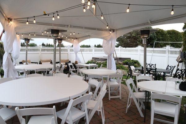 Tent package with 15x40 high peak frame tent, leg drawings, patio heaters, 6ft round tables, garden padded seat chairs, bistro lighting.