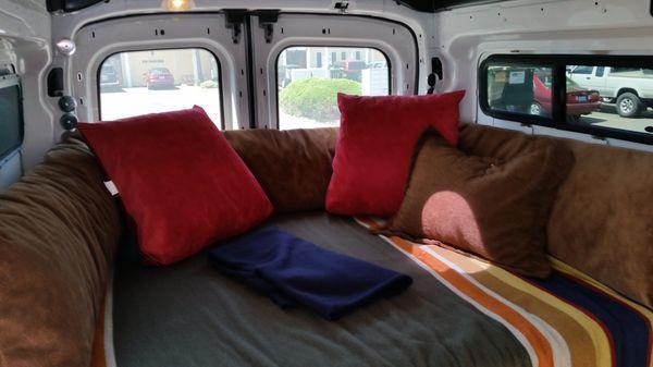 Sprinter Van bed with custom bolster and pillows made to create a relaxing area