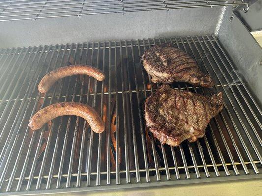 Sausage & rib eye steaks on Weber