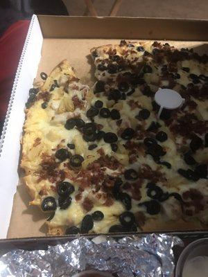 Chicken Alfredo pizza with pineapple and olives and bacon