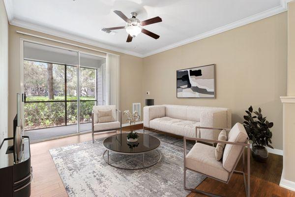 Spacious, bright living room with a ceiling fan, hardwood flooring, and a sliding glass door to a private balcony at Lantower Cypress Creek.