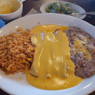 Quesco covered cheese enchiladas with bean and rice