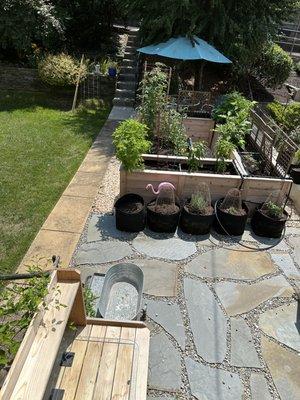 Flagstone and river rock frame for our raised veggie garden boxes.