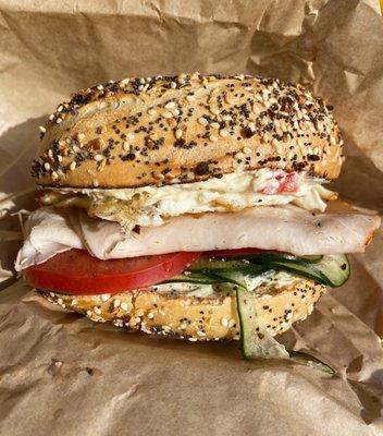 Everything bagel with veggie cream cheese, turkey, egg, tomato, and cucumber