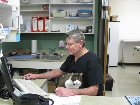 Dr. Gregory can't resist playing with the animals, even when he's hard at work.