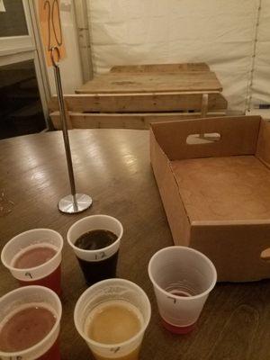 My delicious brews (a "flight"), the box I was given to carry them in, and the outside tent (3/4/21).