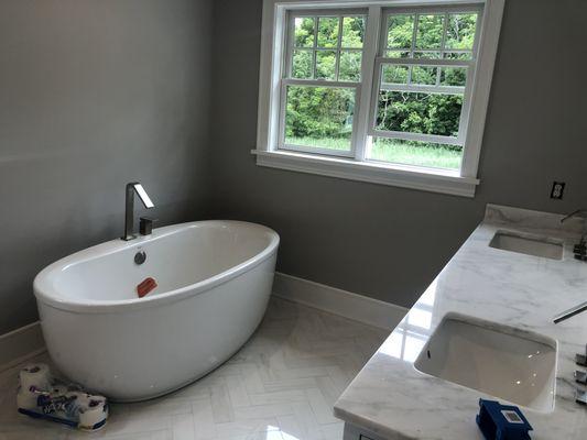 we installed the window, painted the walls ,installed oval Freestanding Tub, installed tiles,  installed cabinets and countertop