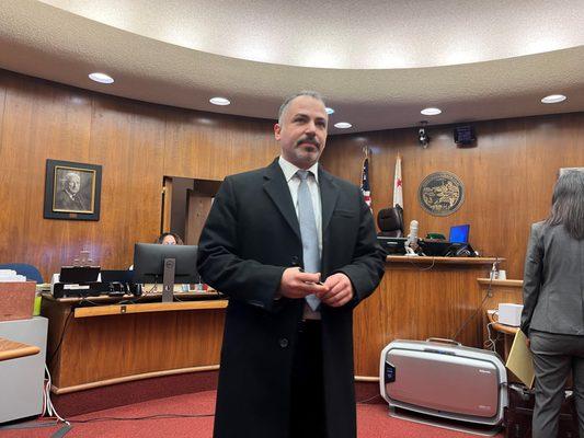 Standing in court as the potential jury pool walks in, ready to try the case.