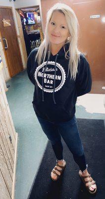 The bar owner displaying one of the bar's sweatshirts