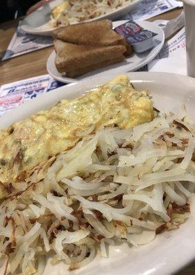 Vegetarian omelet with hash browns,  wheat toast and butter.