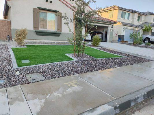 "Enhance curb appeal with HavenHub's artificial turf and decorative rock design, offering a green, low-maintenance front yard solution."