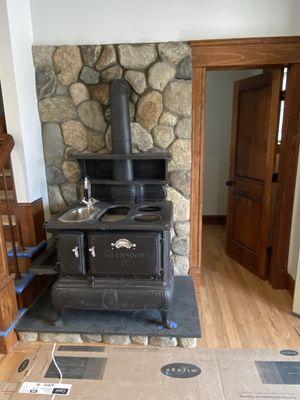 Boston Blend Stone veneer surround the antique wood Stove.