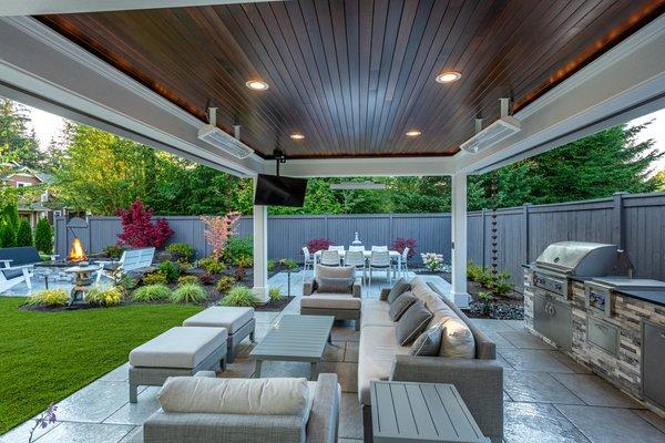 Outdoor kitchen with covered patio structure in a small backyard