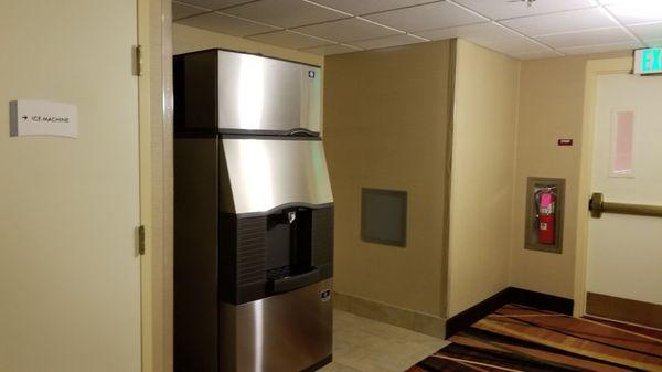 Ice machine at end of hall near emergency exit stairway